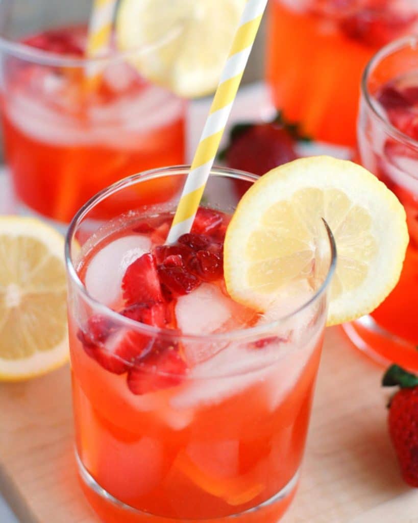 Glass with strawberry lemonade and yellow straw. 