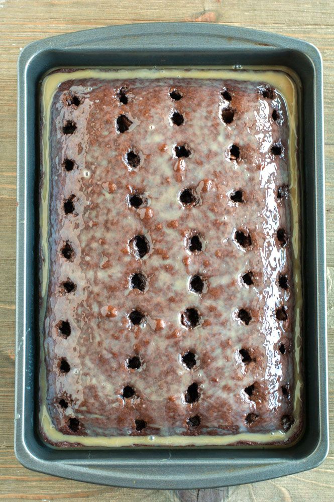 Chocolate Cake in a 9x13 pan with holes poked in the top and glaze poured over.