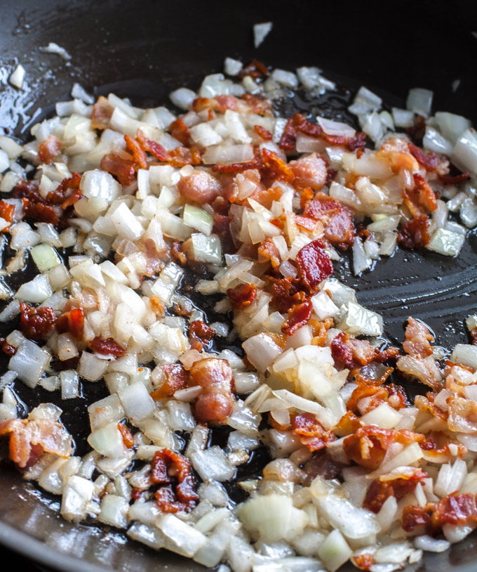 diced bacon and onion cooking in a skillet