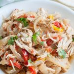 Bowl with shredded chicken, onions and peppers.
