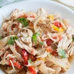 Bowl with shredded chicken, onions and peppers.