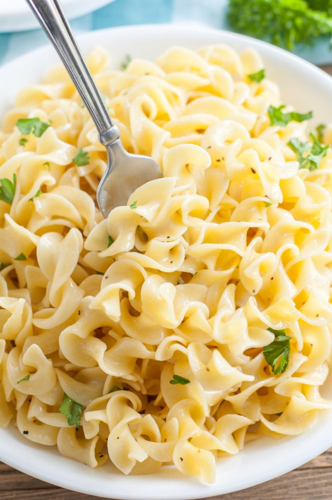 Buttered noodles in a bowl with a fork