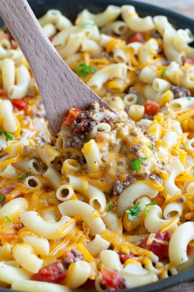 hamburger casserole in a skillet with wooden spoon