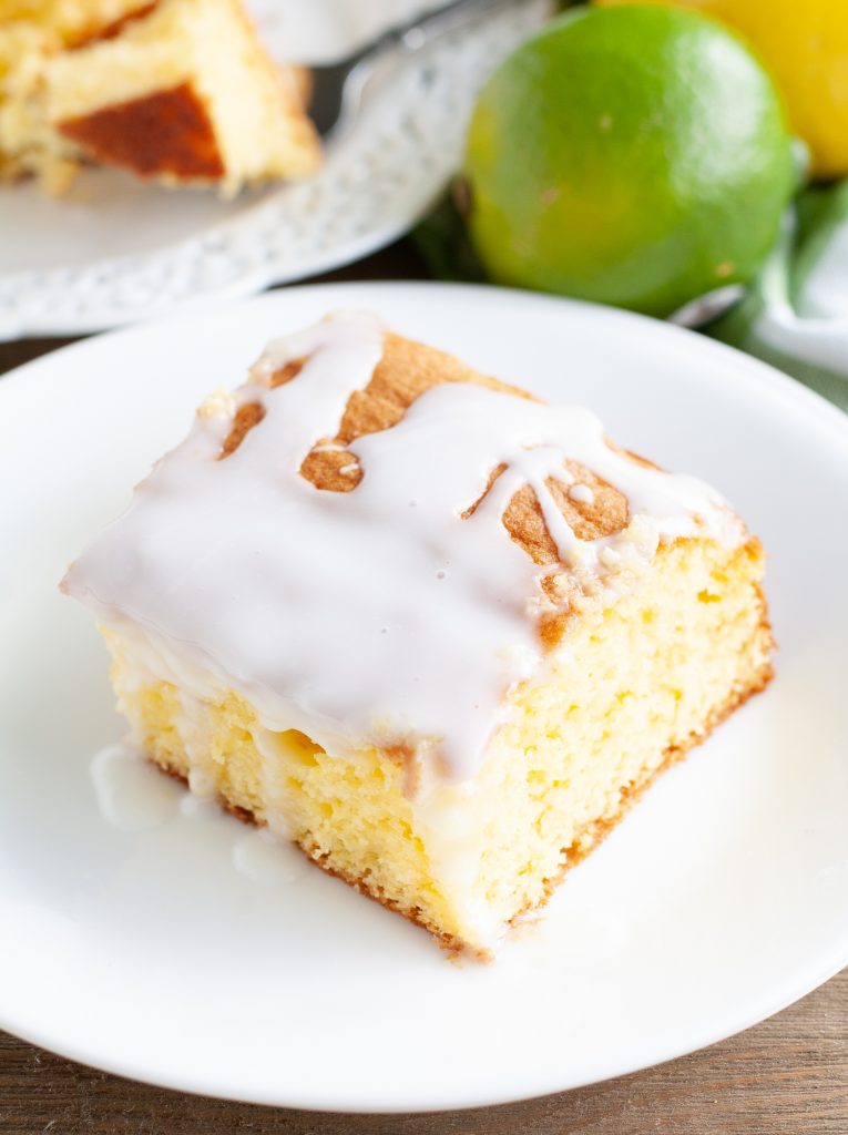 A piece of cake on plate with lime in the background