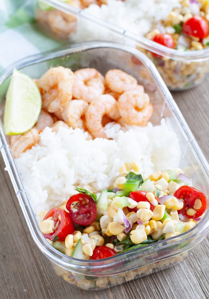 Container with shrimp, white rice and corn and tomatoes. 