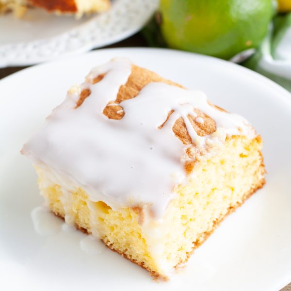 Piece of cake with icing, lemon and limes.