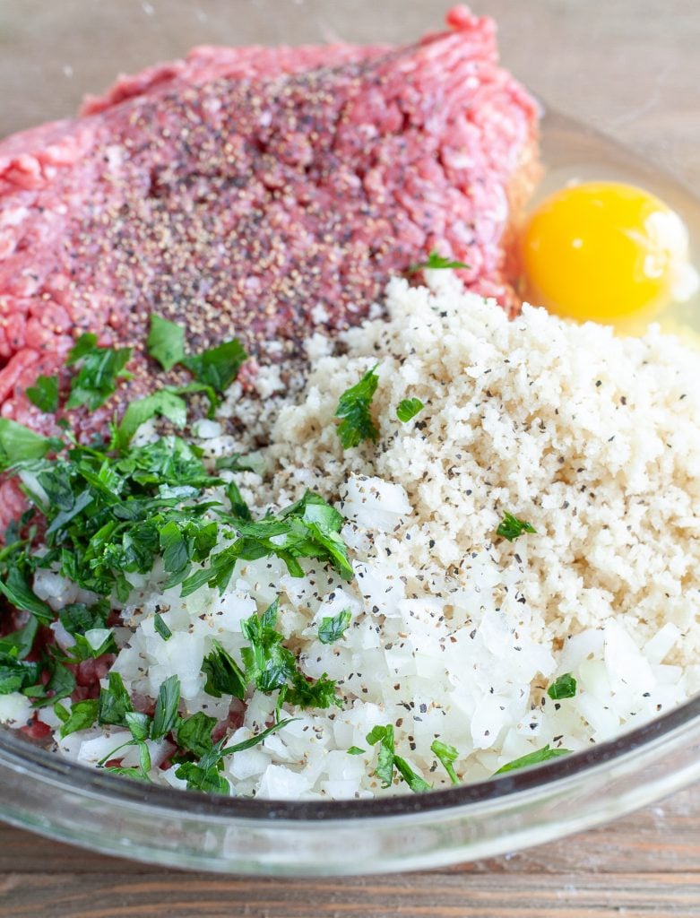 Ground beef, parsley, onion, panko, egg in a glass bowl