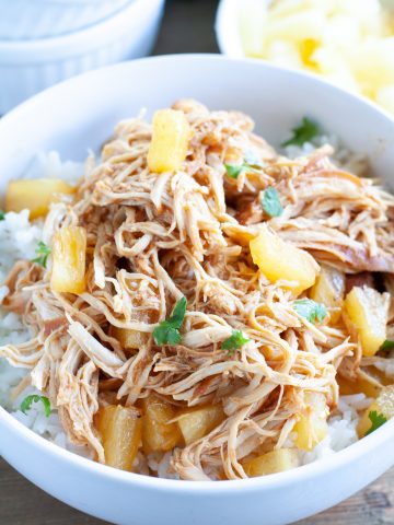 Bowl of rice with shredded chicken and diced pineapple.