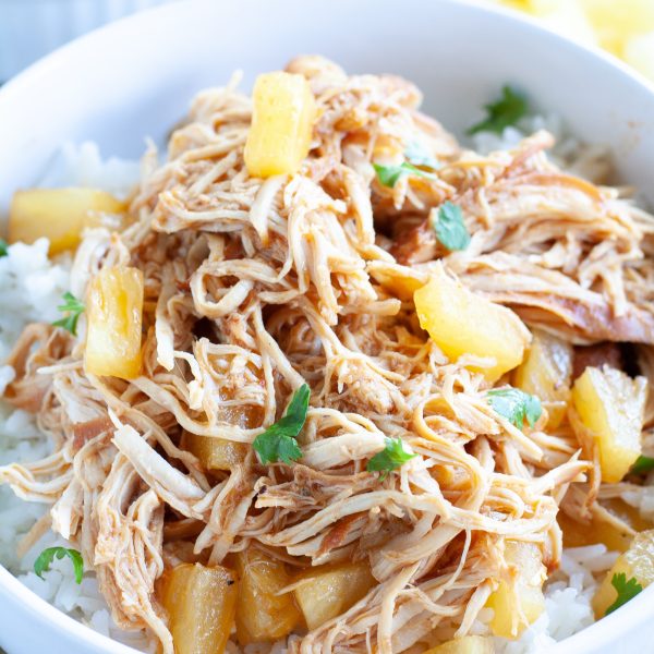 Bowl of rice with shredded chicken and diced pineapple.