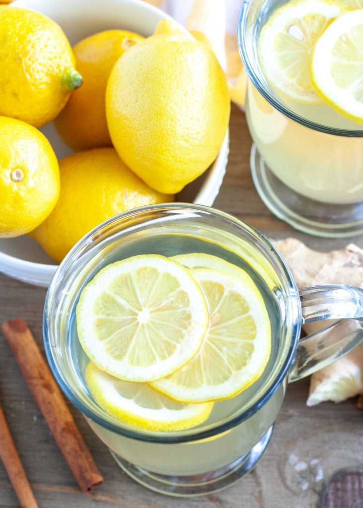 Glass of tea with a bowl of lemons 