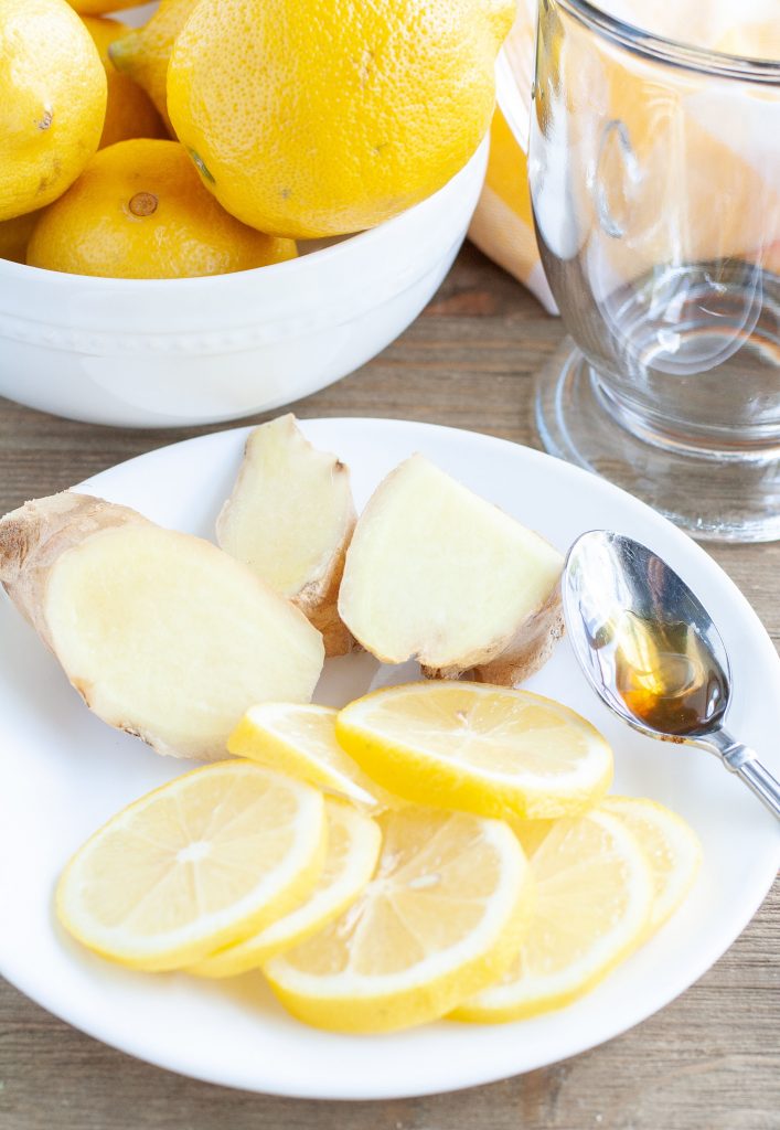 Bowl of lemons, plate of sliced lemon and ginger root