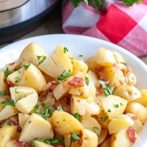 Bowl with cut potatoes, bacon bits and parsley.