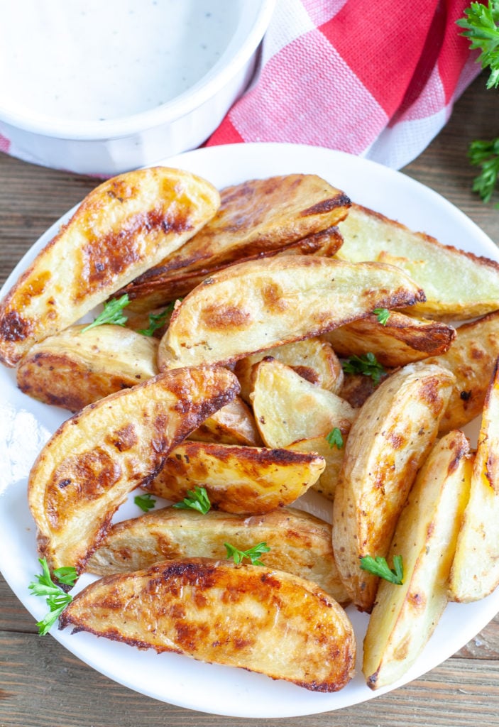 Potato wedges on a plate with ranch dipping sauce