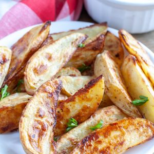 Cooked potato wedges on plate.