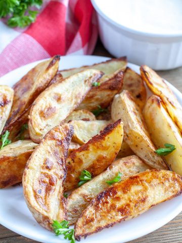 Cooked potato wedges on plate.