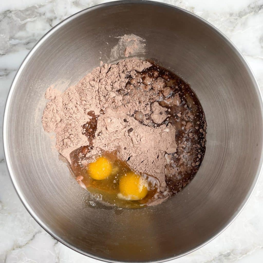 Mixing bowl with eggs, chocolate cake mix, and milk. 