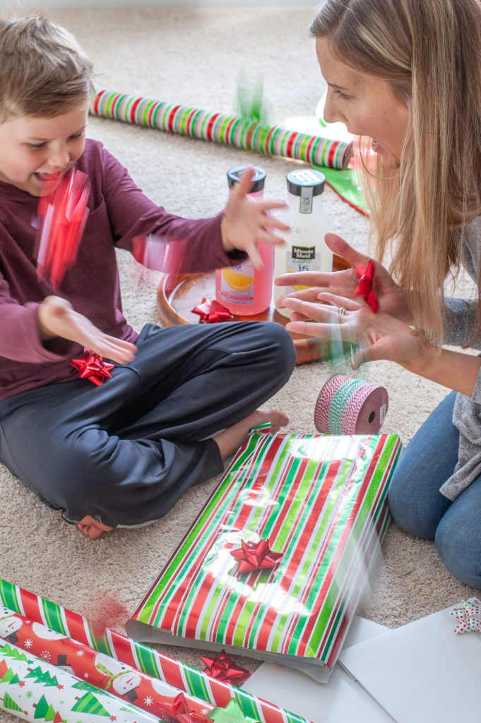 A women and little boy with wrapped present. 