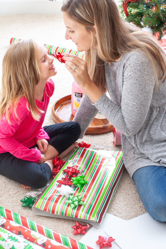 A woman and girl with wrapping paper. 