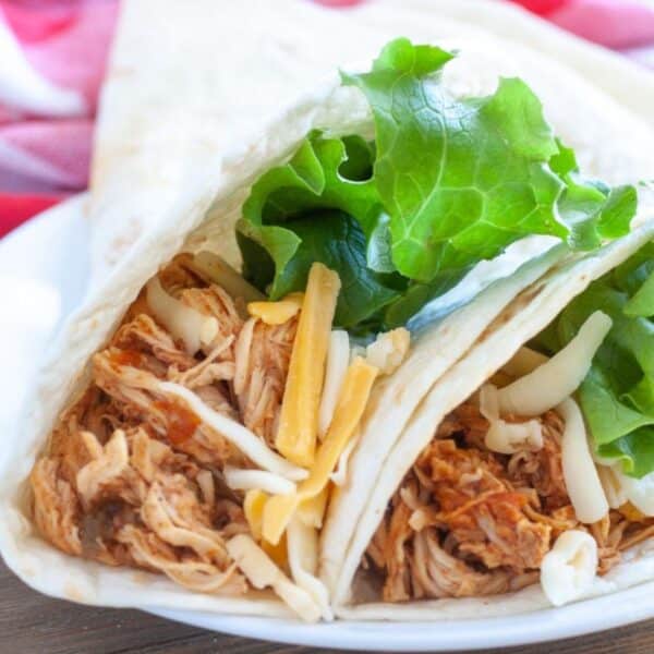 Two chicken soft tacos on a plate.