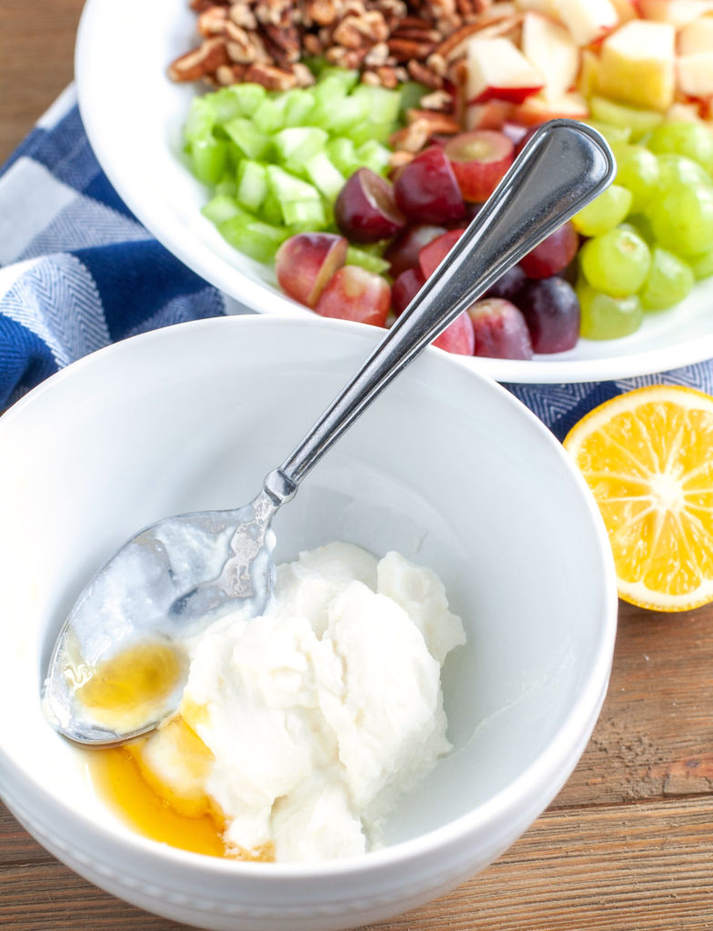 Waldorf Salad dressing in a white bowl with spoon.