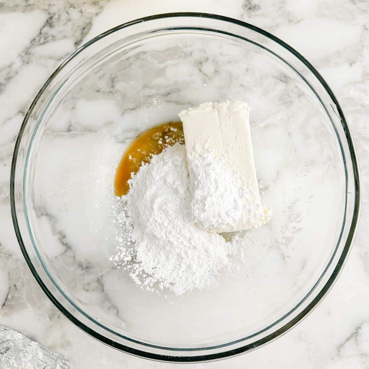 Bowl with cream cheese, powdered sugar, and vanilla. 