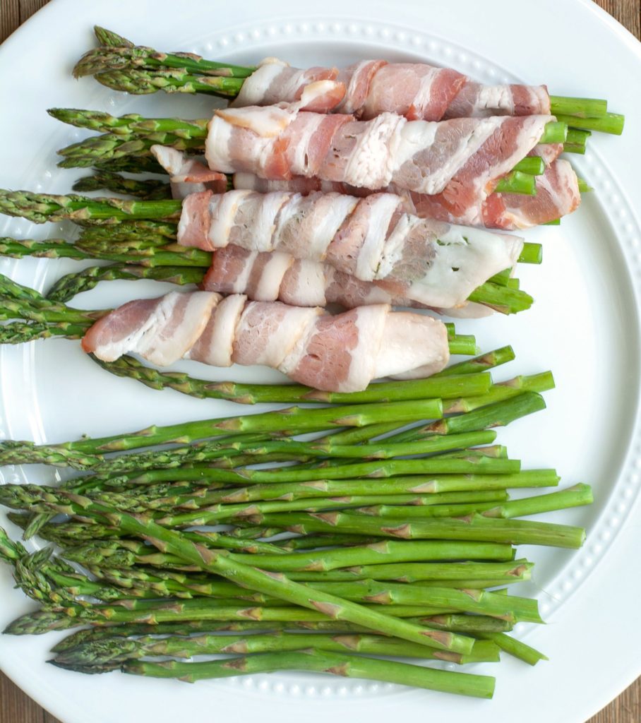 Bacon wrapped around asparagus on a plate