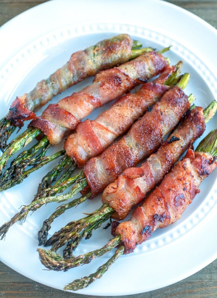 Bacon wrapped asparagus on a white plate