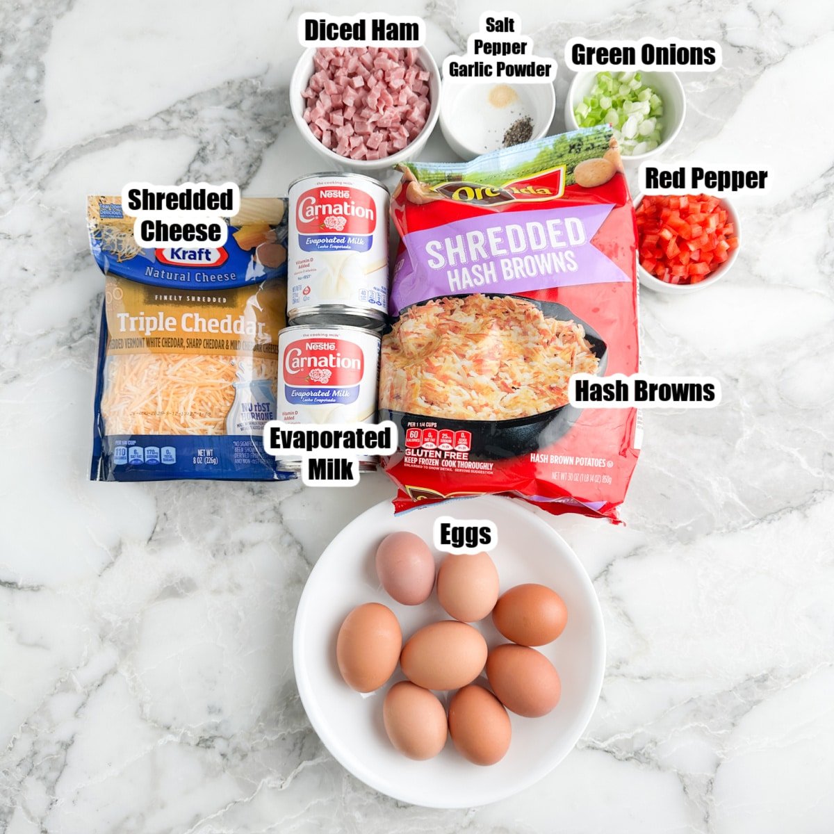 Bag of hash browns, eggs, cheese, ham, evaporated milk, red peppers, and green onions.