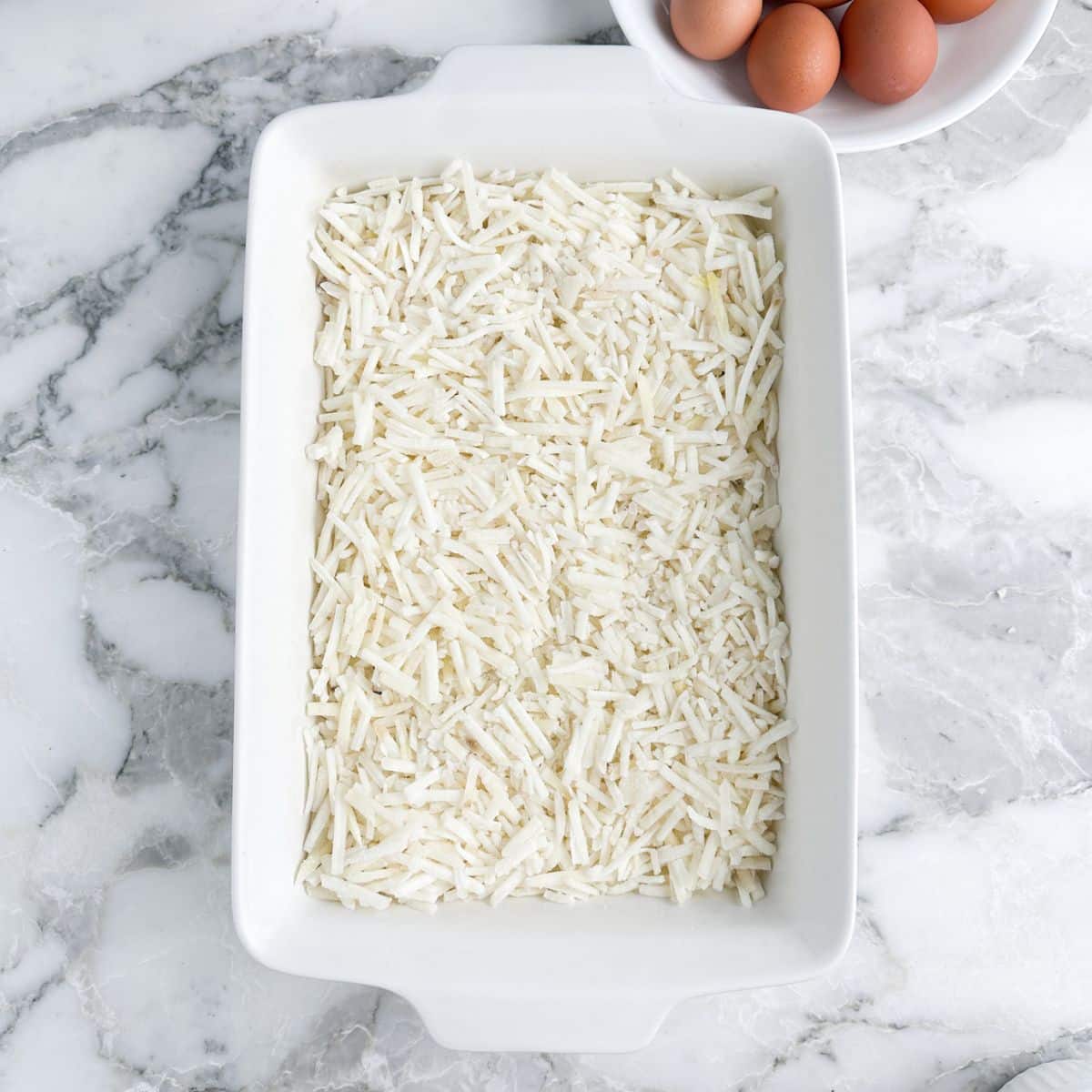 Casserole dish with frozen hash browns.