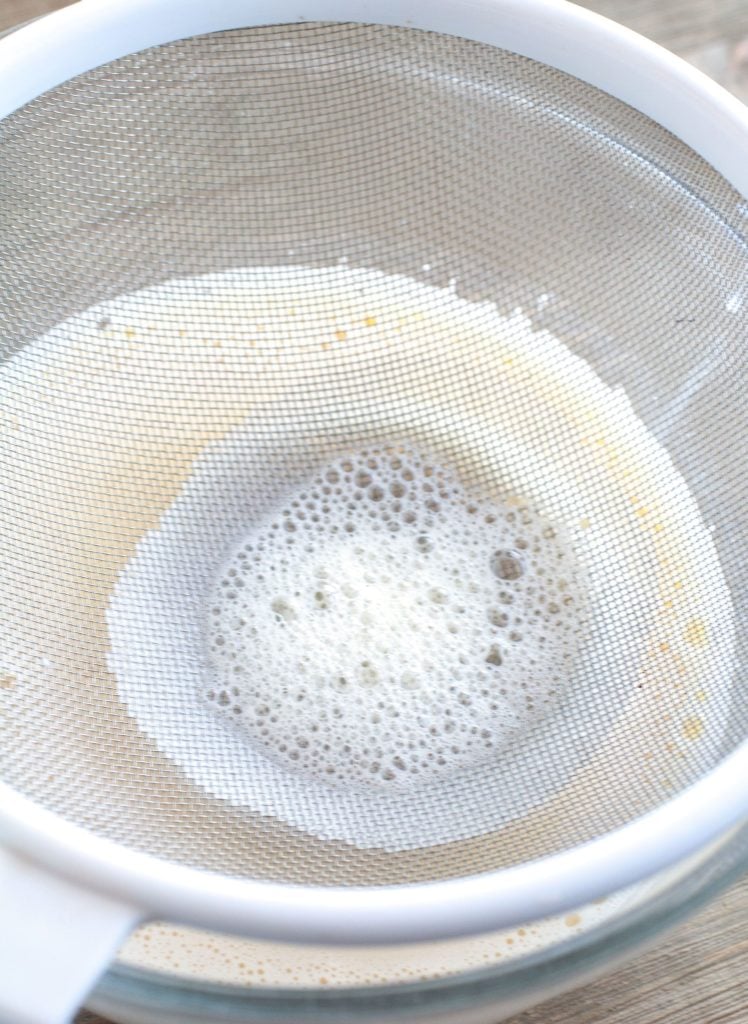 Strainer on top of a bowl with egg mixture