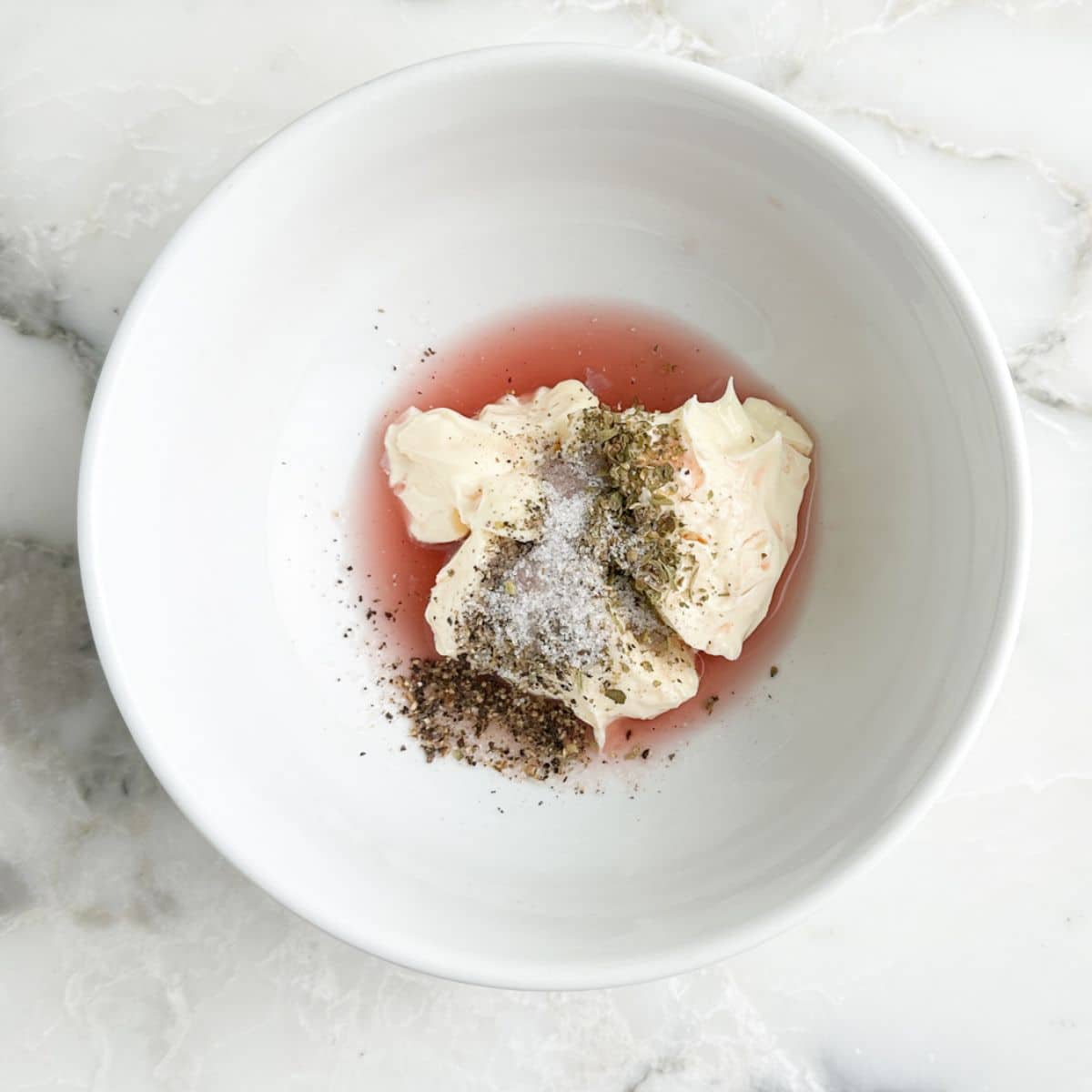 Bowl of mayonnaise, vinegar, and seasonings. 