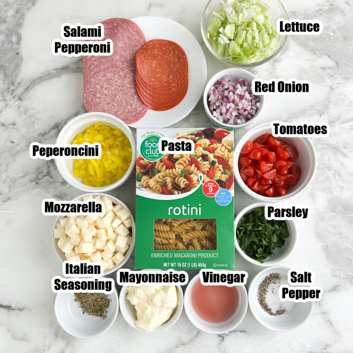 Pasta, cubed cheese, mayonnaise, lettuce, onions, deli meat, tomatoes, and seasoning. 