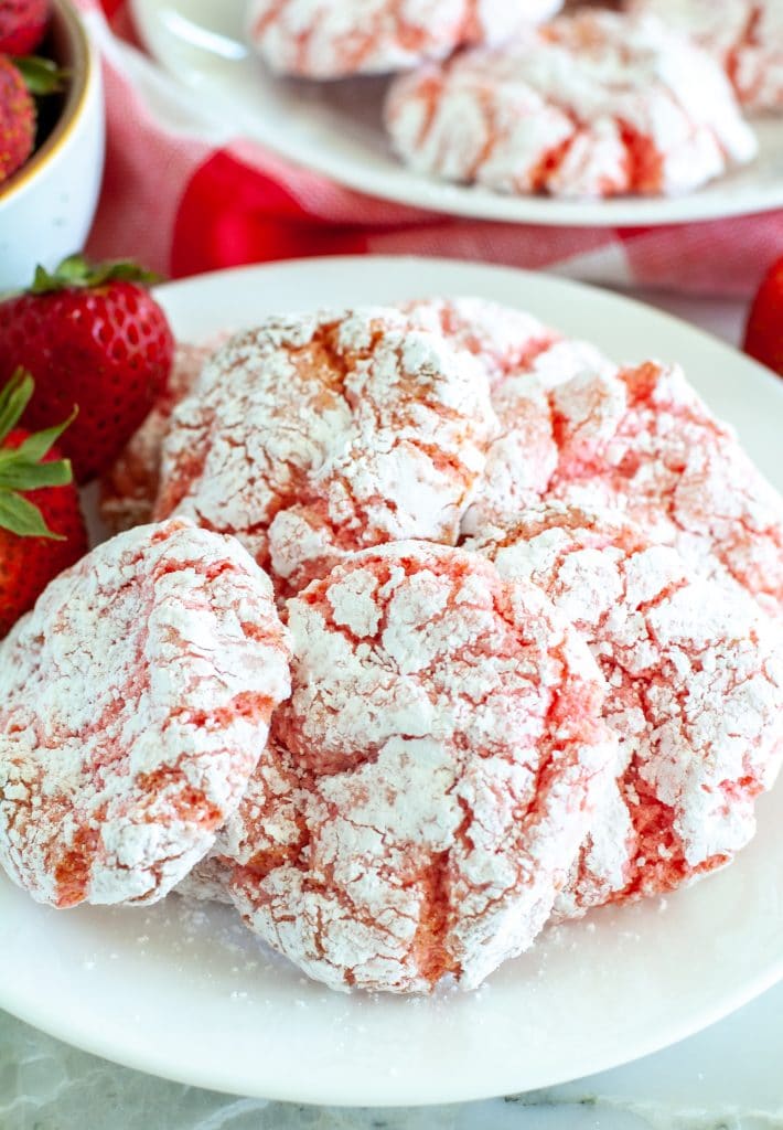 strawberry cookies on a plate with 2 strawberries