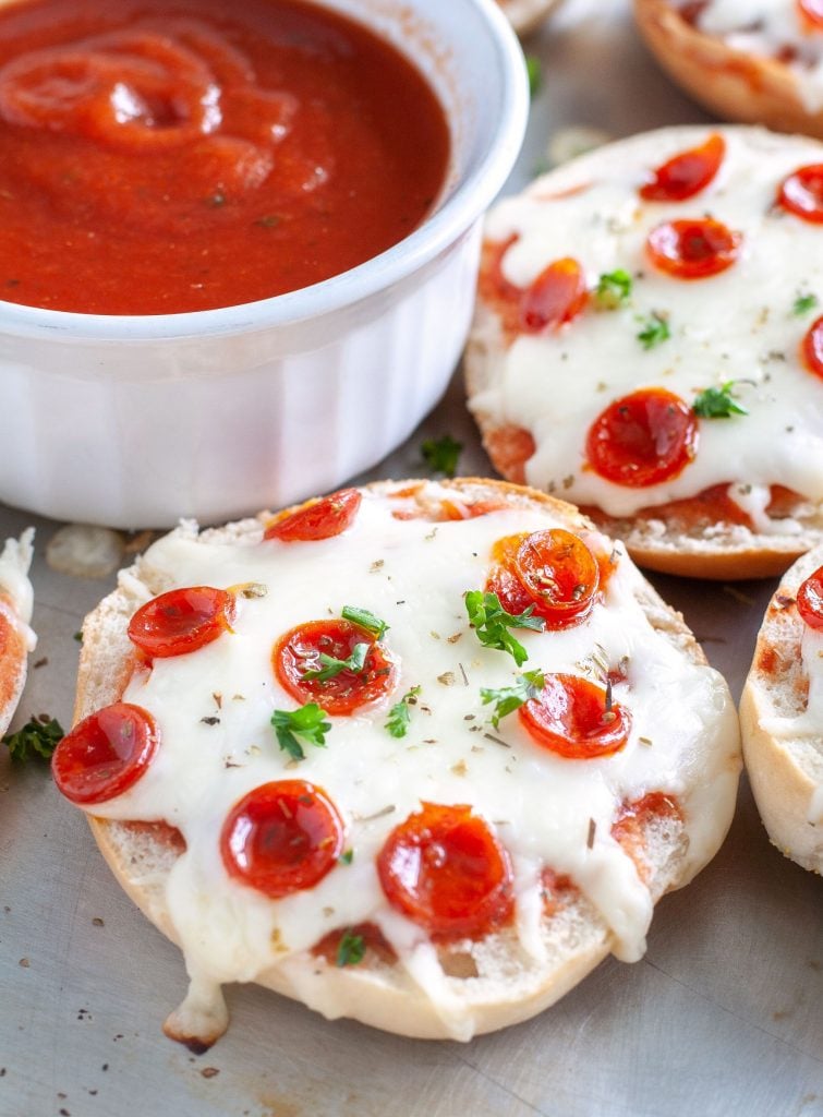 Pizza Bagels on a pan and bowl of marinara sauce