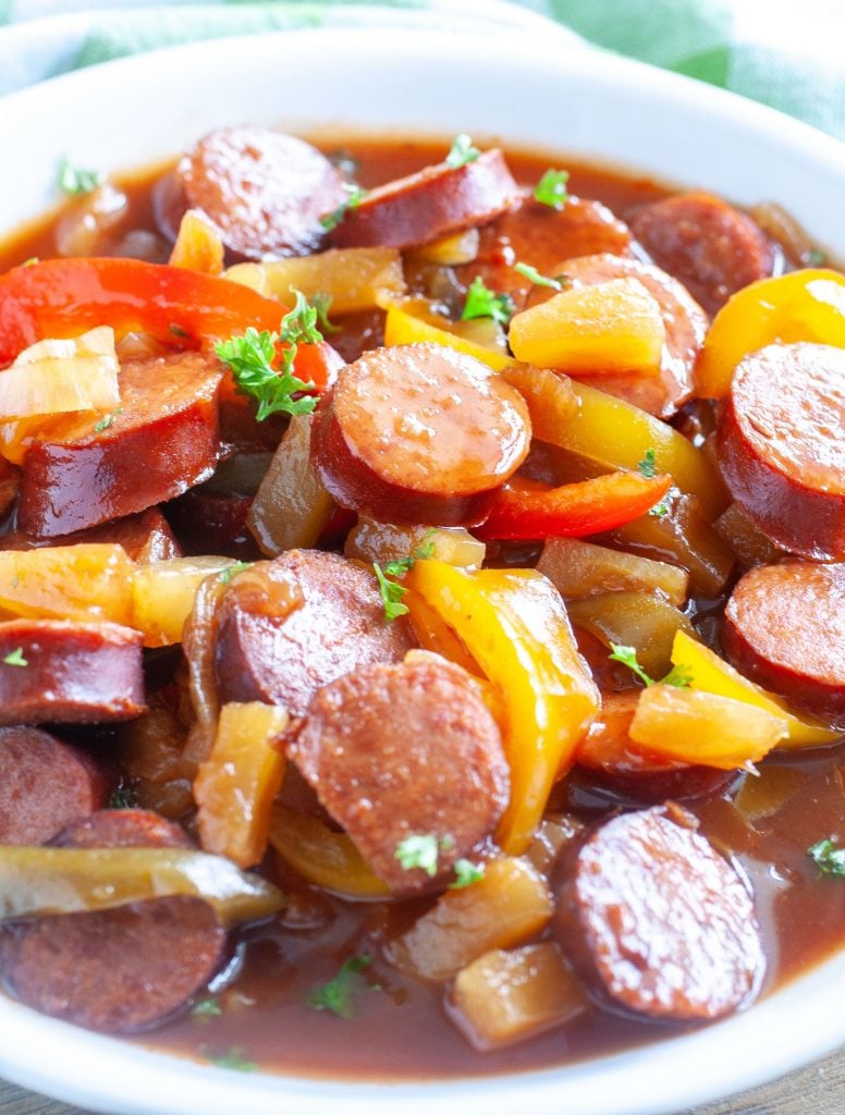 A bowl of sweet and sour kielbasa with onions and peppers