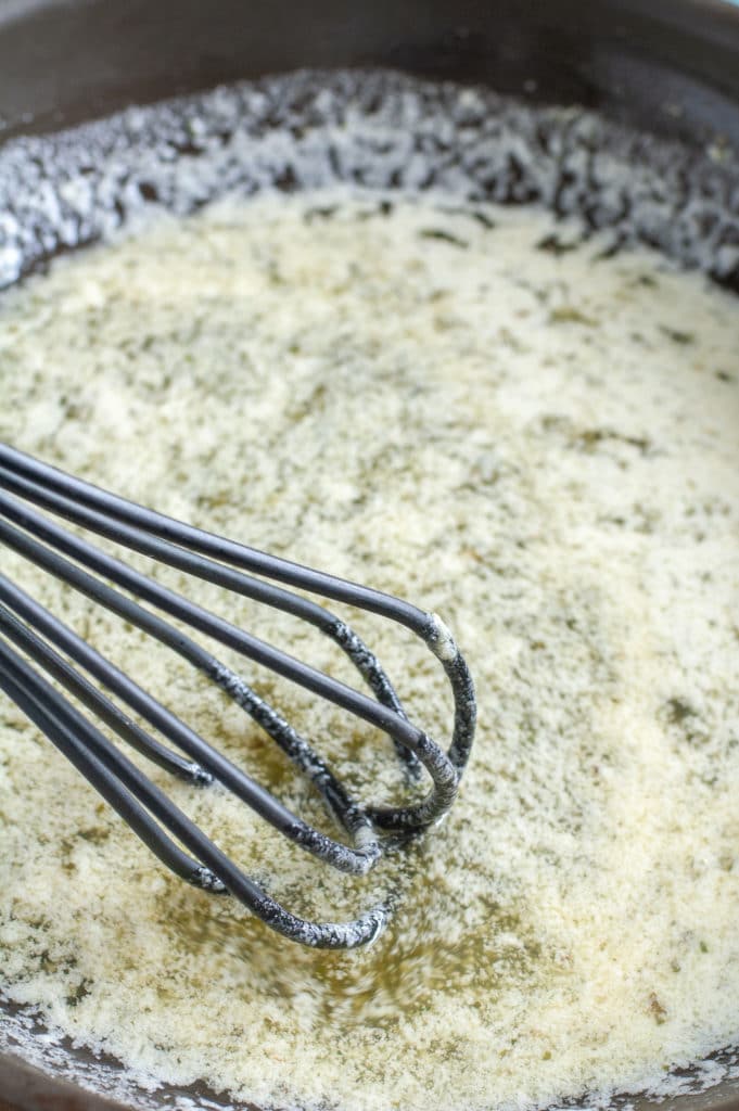 Melted butter and seasoning in a skillet with a whisk. 