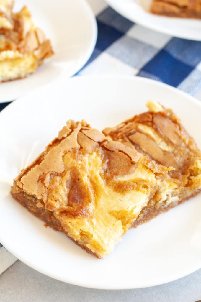 2 cream cheese swirled blondies on a white plate