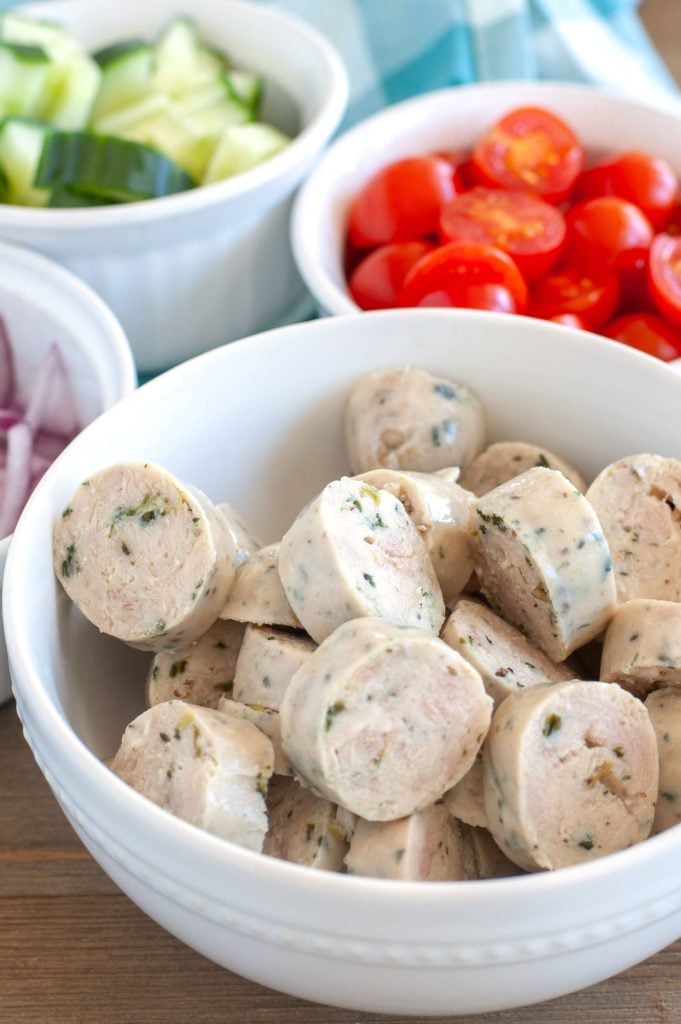 Bowl of sliced chicken sausage, cucumbers and tomatoes