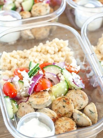 Containers with sausage, cucumbers, tomatoes and couscous.