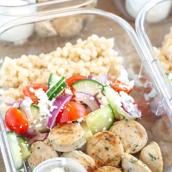 Containers with sausage, cucumbers, tomatoes and couscous.