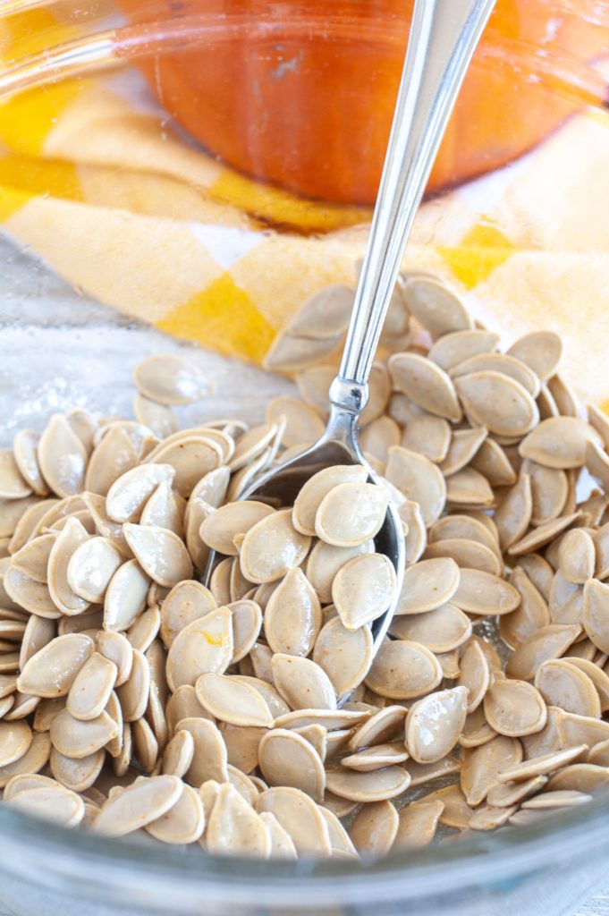 Pumpkin Seeds in a bowl with olive oil and seasoned salt