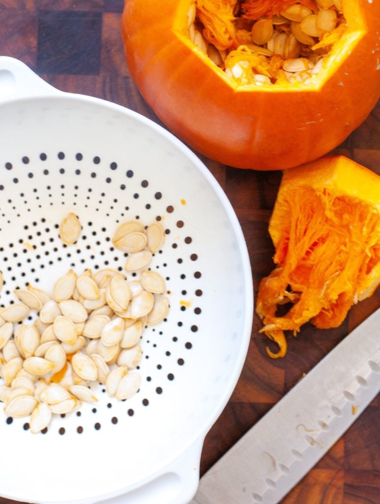 Collandar with pumpkin seeds and a small pumpkin with seeds