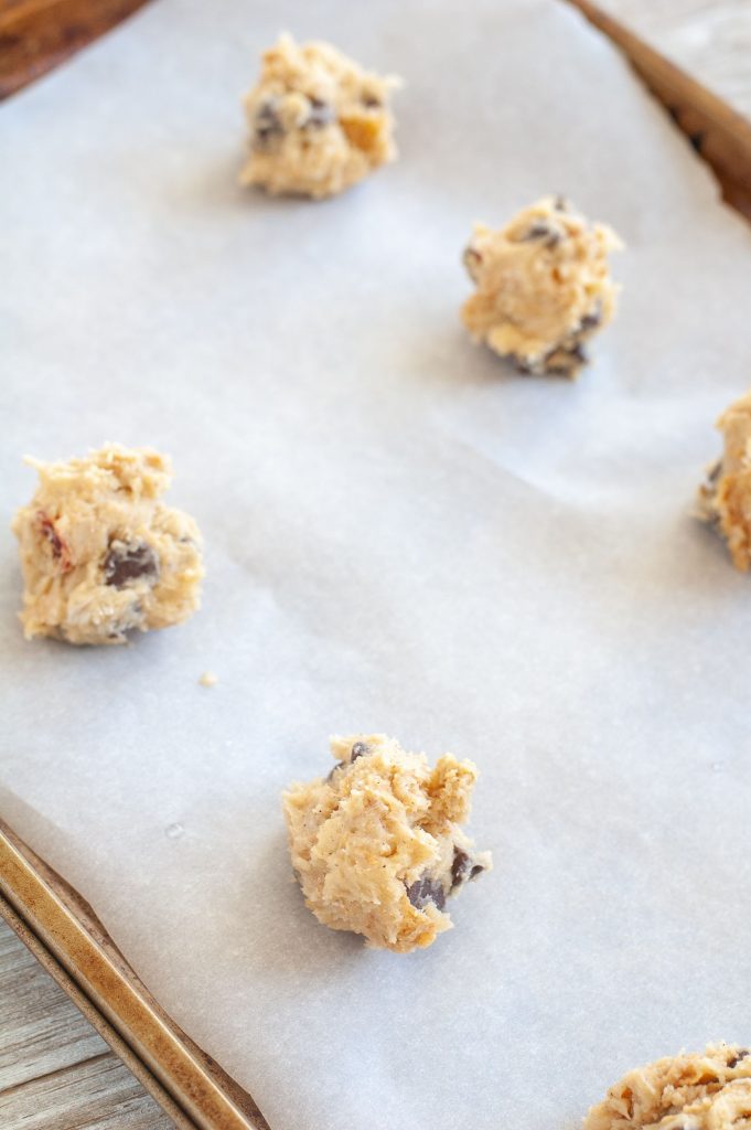 Scoops of chocolate chip cookies on a baking sheet