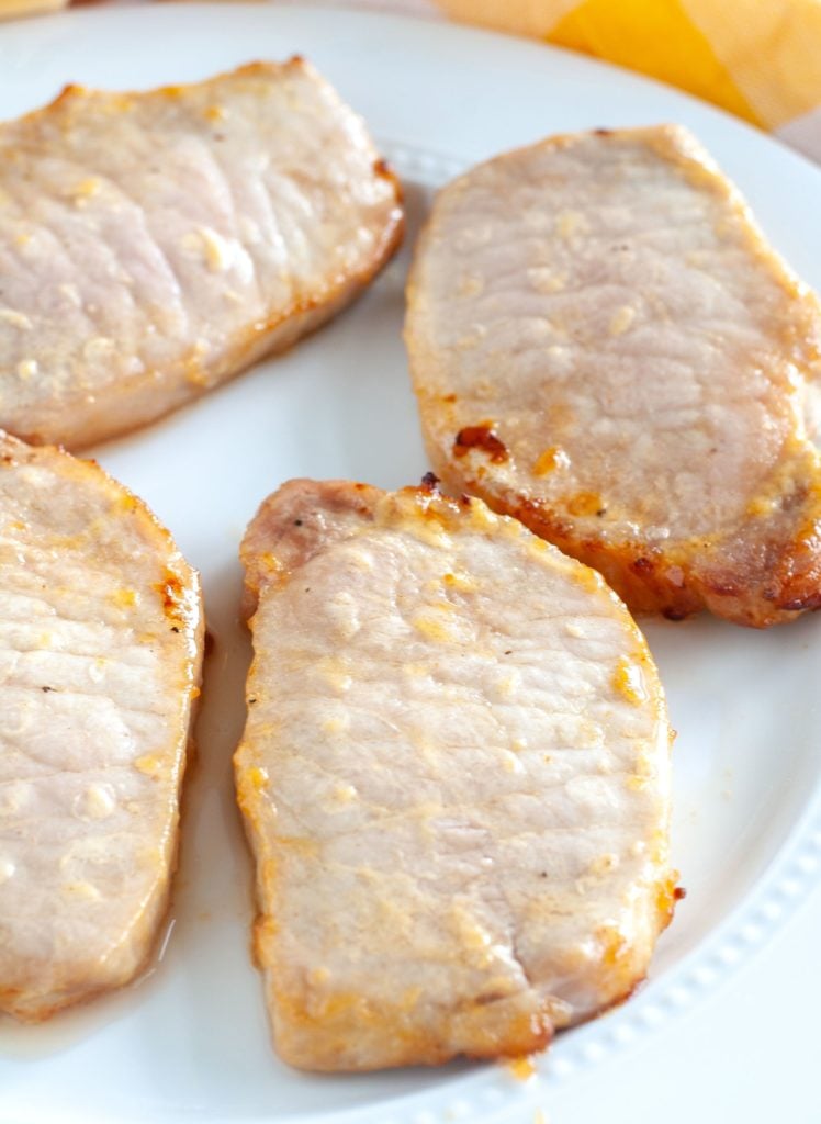 4 pork chops on a white plate