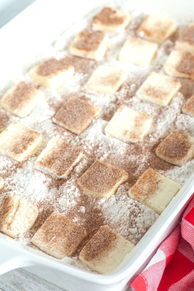 Cake batter with pats of butter on top in casserole dish. 