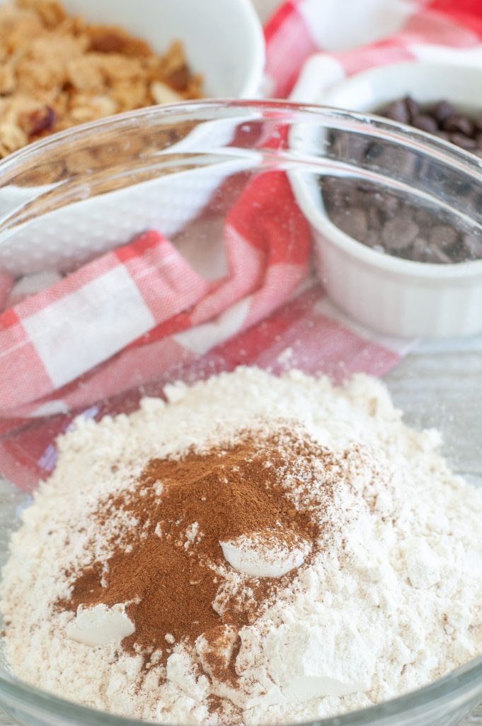 Bowl of flour, cinnamon, nutmeg, bowl of chocolate chips and cereal