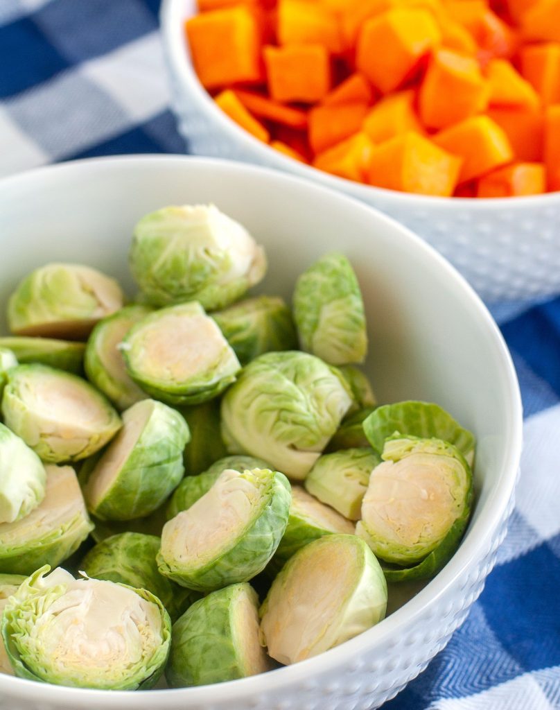 Bowl of brussels sprouts and a bowl of cut up butternut squash