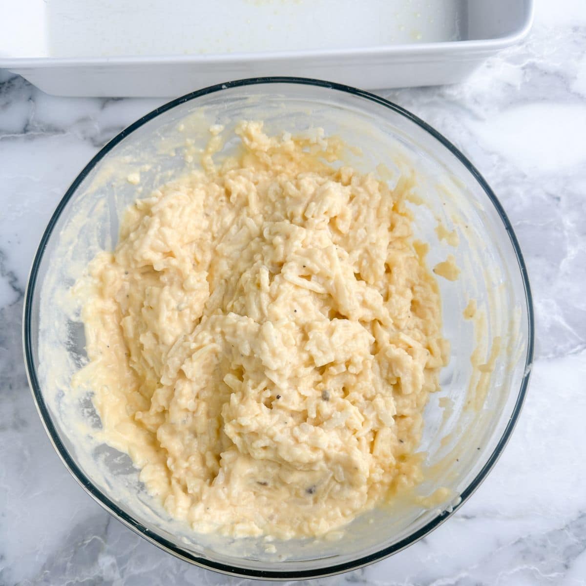 Bowl with hash brown casserole mixture.