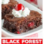 Brownie with cherries on plate.