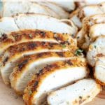 Cooked chicken breast sliced on plate.